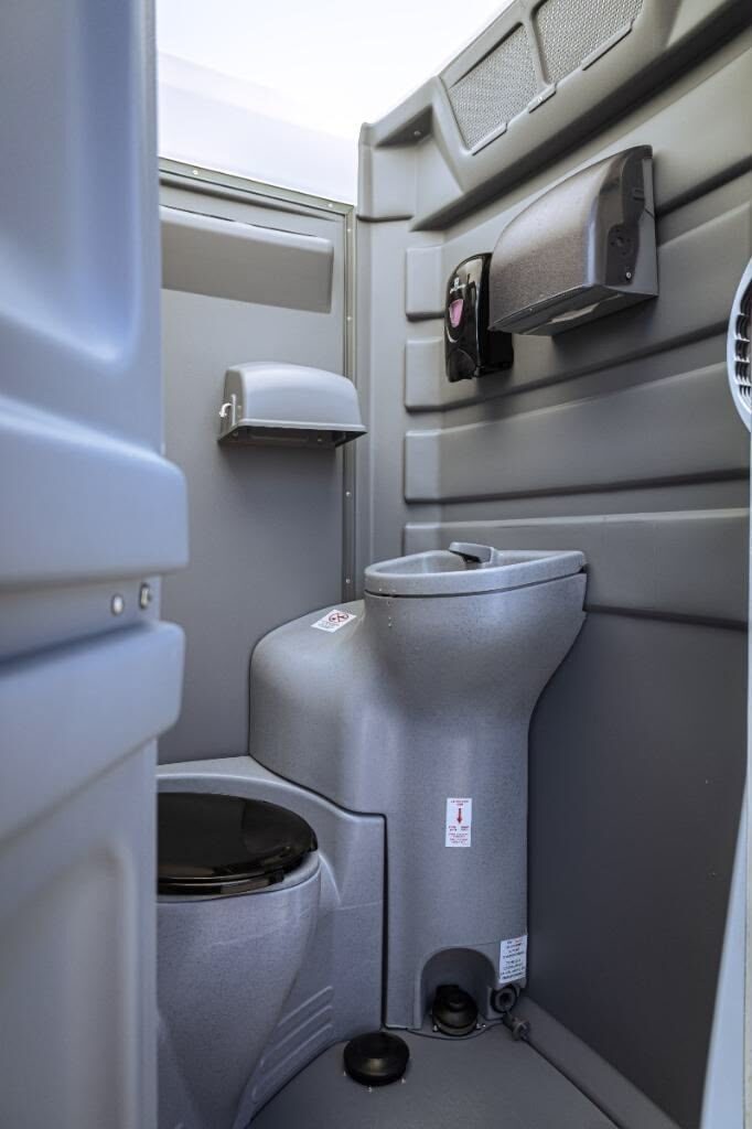 Interior close-up of a clean event restroom unit with fixtures