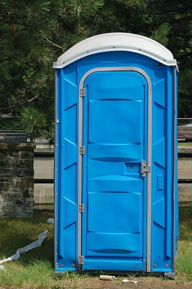 Portable toilet placed at a remote, long-term site surrounded by trees
